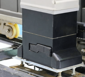 Close-up of an automatic sliding gate motor's gear rack and wheel mechanism, demonstrating the robust components for smooth gate operation.